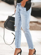 NEWYORKLISTED STYLE COLLECTION: Person wearing light blue ripped jeans with a blurred background