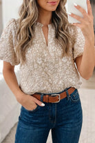 NEWYORKLISTED STYLE COLLECTION: Woman wearing a beige floral blouse and blue jeans, holding a phone.