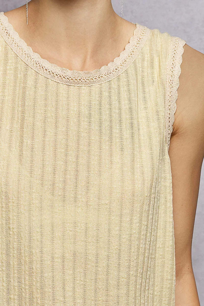 NEWYORKLISTED STYLE COLLECTION: Close-up of a beige sleeveless top with lace trim on a plain background