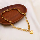 NYLD Glamour Collection by NEWYORKLISTED: Gold chain bracelet with a heart charm on a wooden tray
