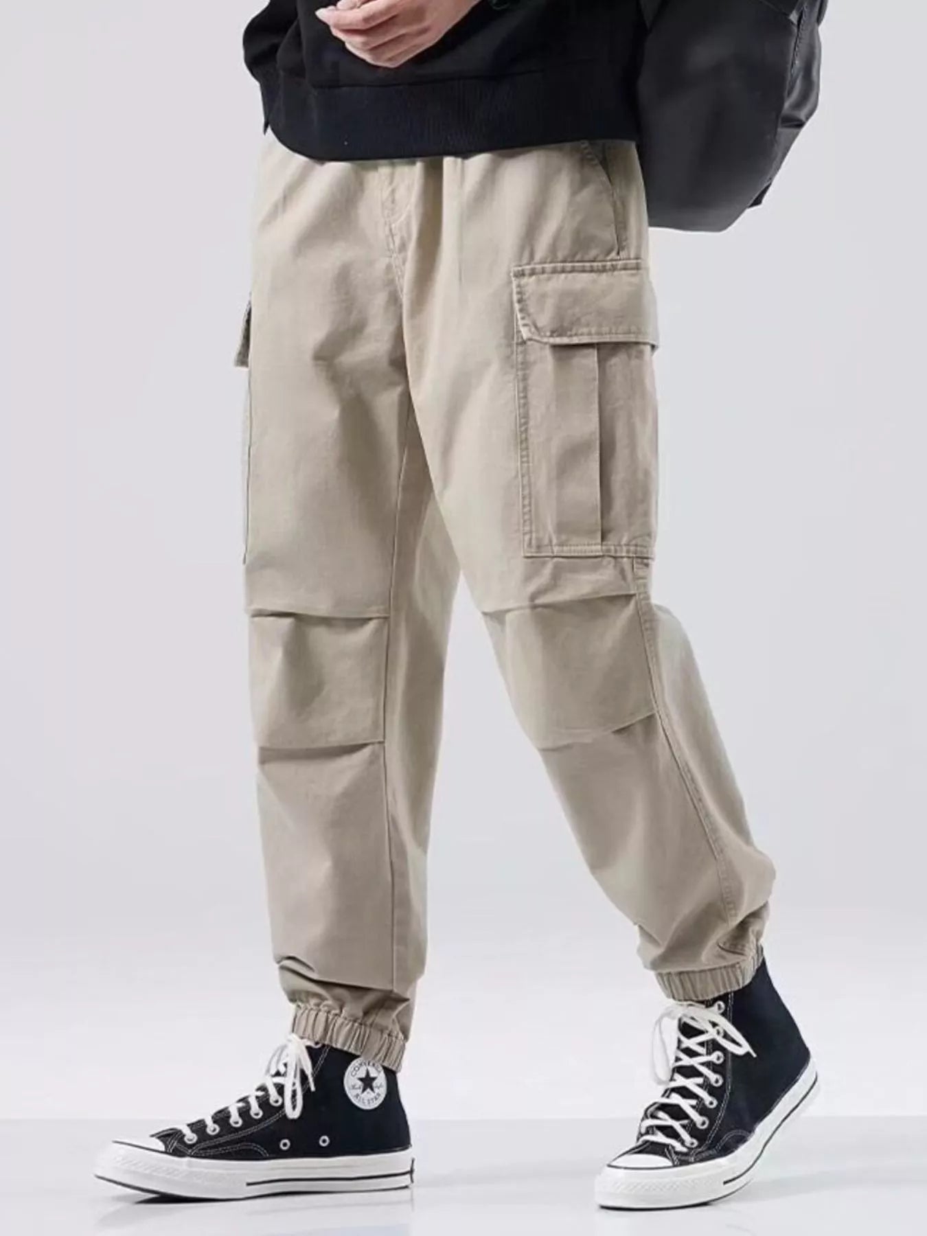 NEWYORKLISTED ATLAS MEN'S COLLECTION: Person wearing beige cargo pants with a plain background