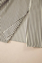 NEWYORKLISTED STYLE COLLECTION: Close-up of a black and white striped shirt on a beige background