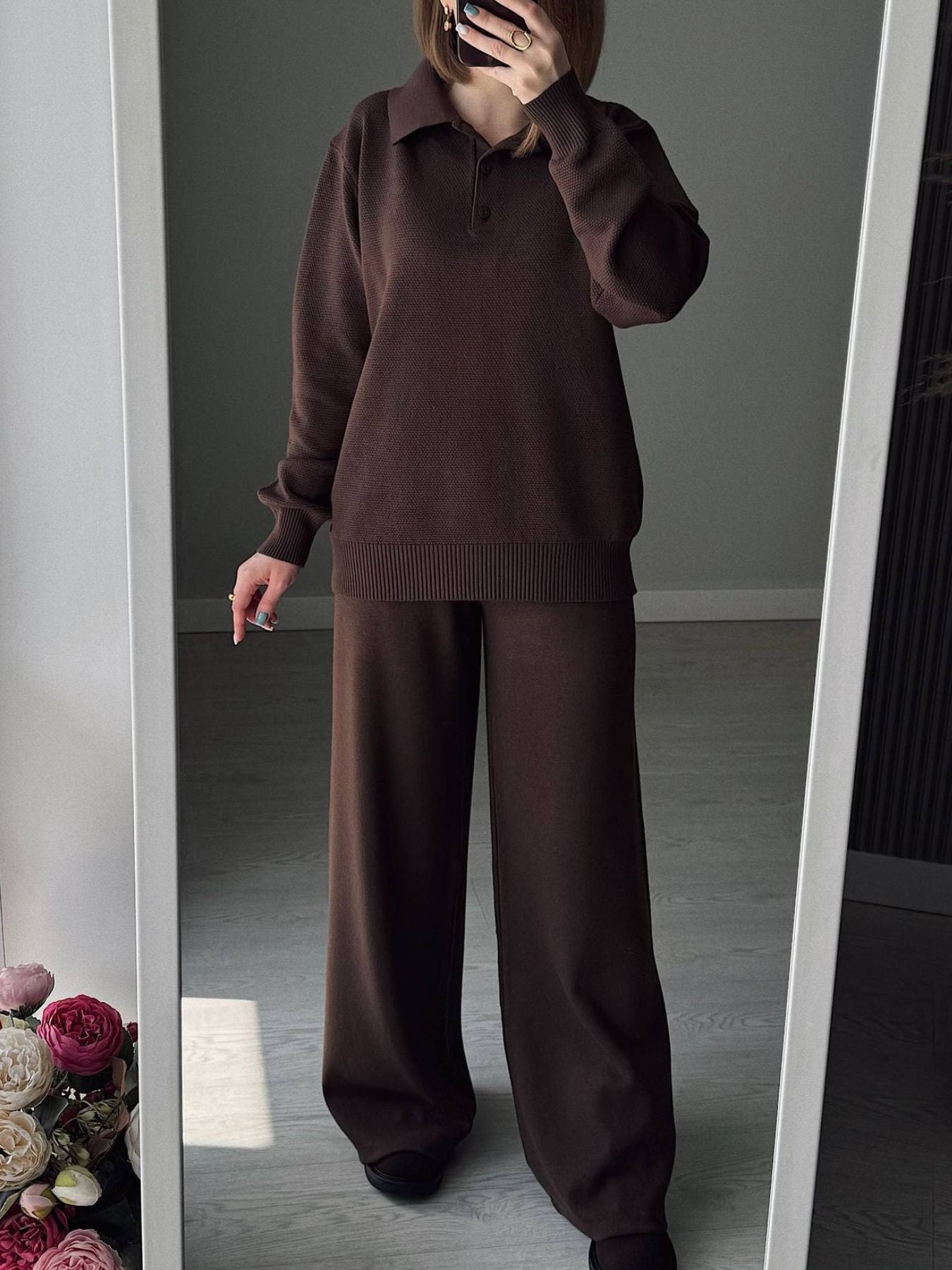 NEWYORKLISTED Comfort Collection: Person wearing a brown sweater and pants standing in front of a mirror.
