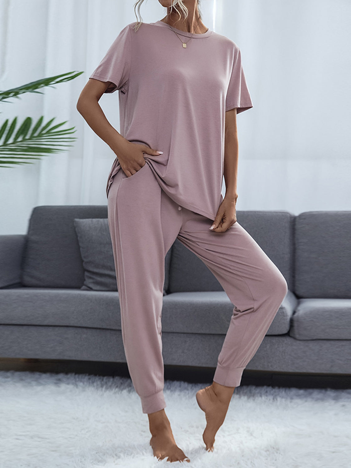 NEWYORKLISTED Intimate Apparel: Person wearing a mauve pajama set in a living room setting.