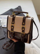 NEWYORKLISTED STYLE COLLECTION: Two-tone handbag with brown and beige colors held by a person, with a magazine in the background.