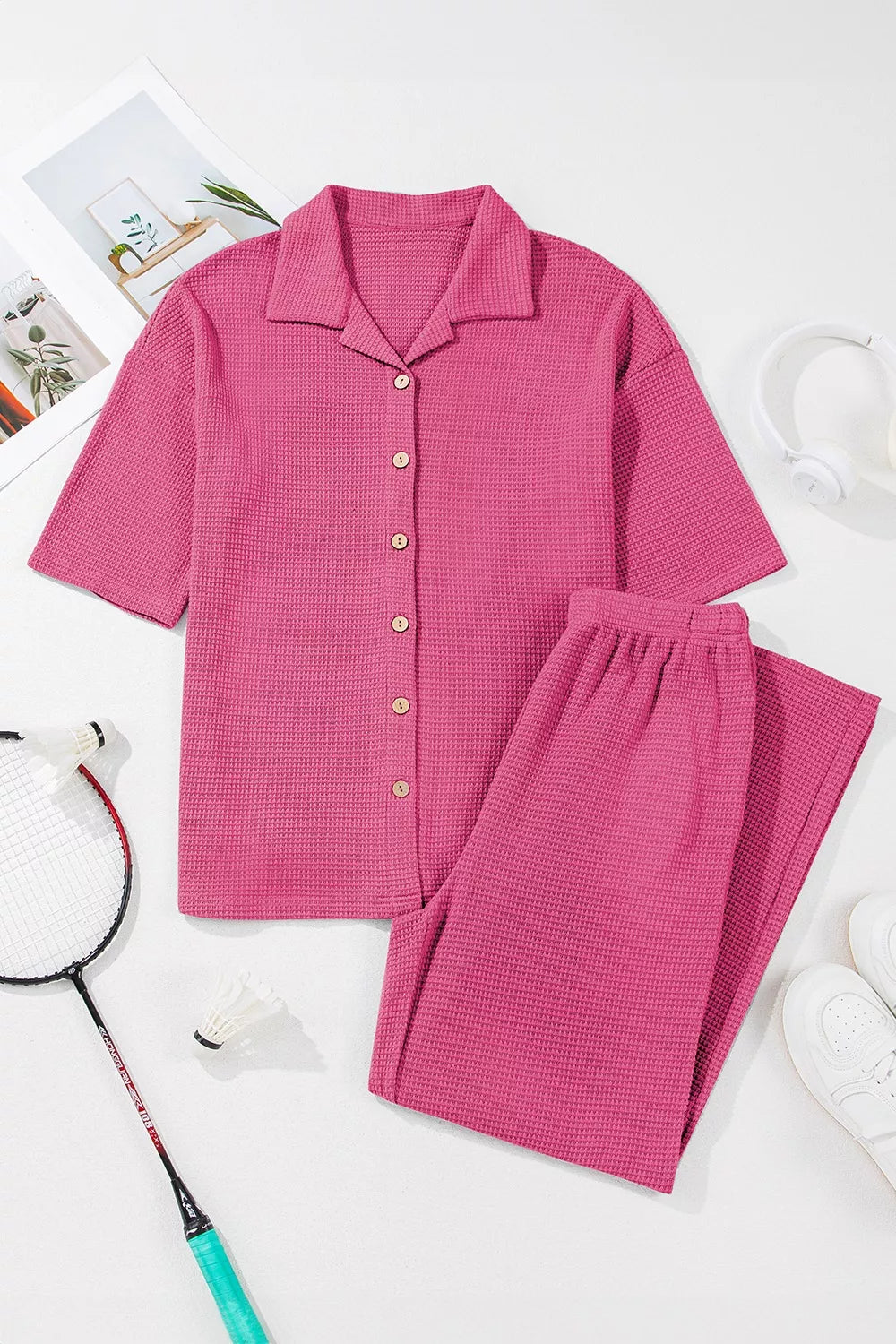 NEWYORKLISTED Comfort Collection: Pink checkered shirt and pants set on a white background with a badminton racket.