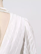 NEWYORKLISTED STYLE COLLECTION: White dress with a sheer overlay on a mannequin against a light gray background