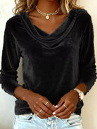 NEWYORKLISTED STYLE COLLECTION: Person wearing a black long-sleeve top with a cowl neckline, gold jewelry, and light blue jeans.