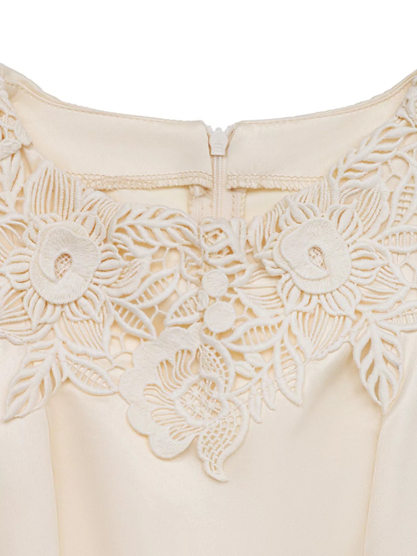 NEWYORKLISTED STYLE COLLECTION: Close-up of a cream-colored garment with floral lace details