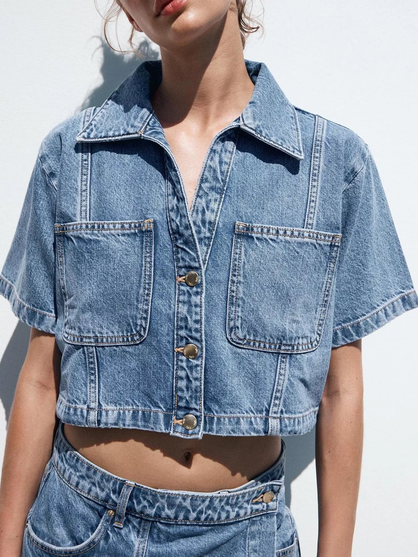 NEWYORKLISTED STYLE COLLECTION: Person wearing a blue denim jacket and shorts against a white background