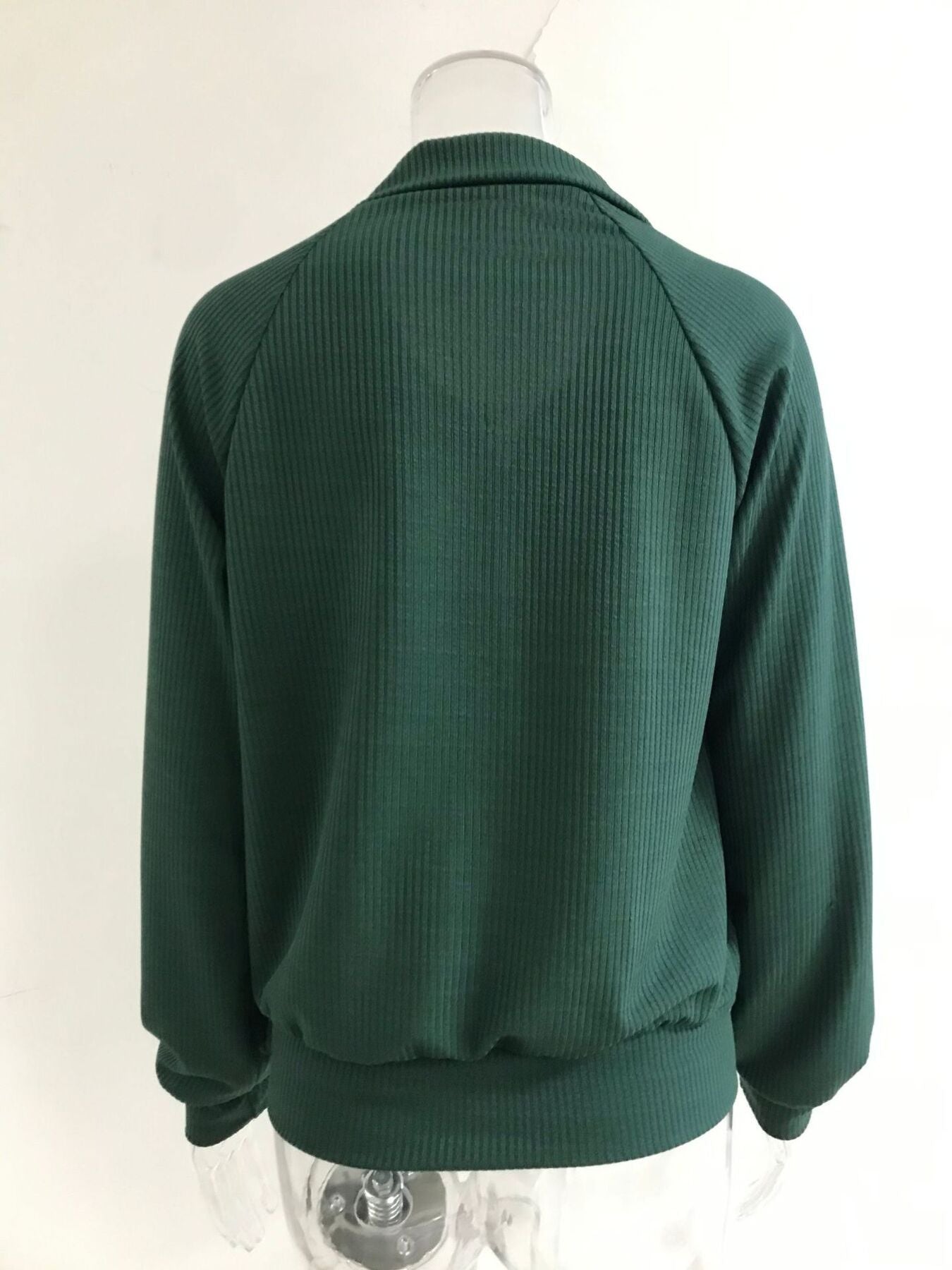 NEWYORKLISTED STYLE COLLECTION: Green ribbed sweater on a mannequin against a white background