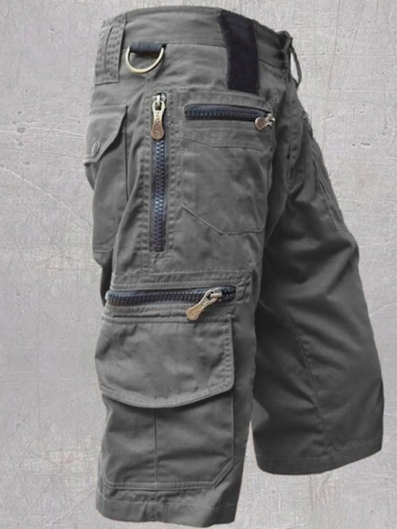 NEWYORKLISTED ATLAS MEN'S COLLECTION: Gray cargo shorts with multiple pockets and zippers on a gray background
