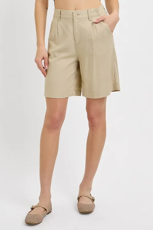 NEWYORKLISTED STYLE COLLECTION: Person wearing beige shorts on a plain background