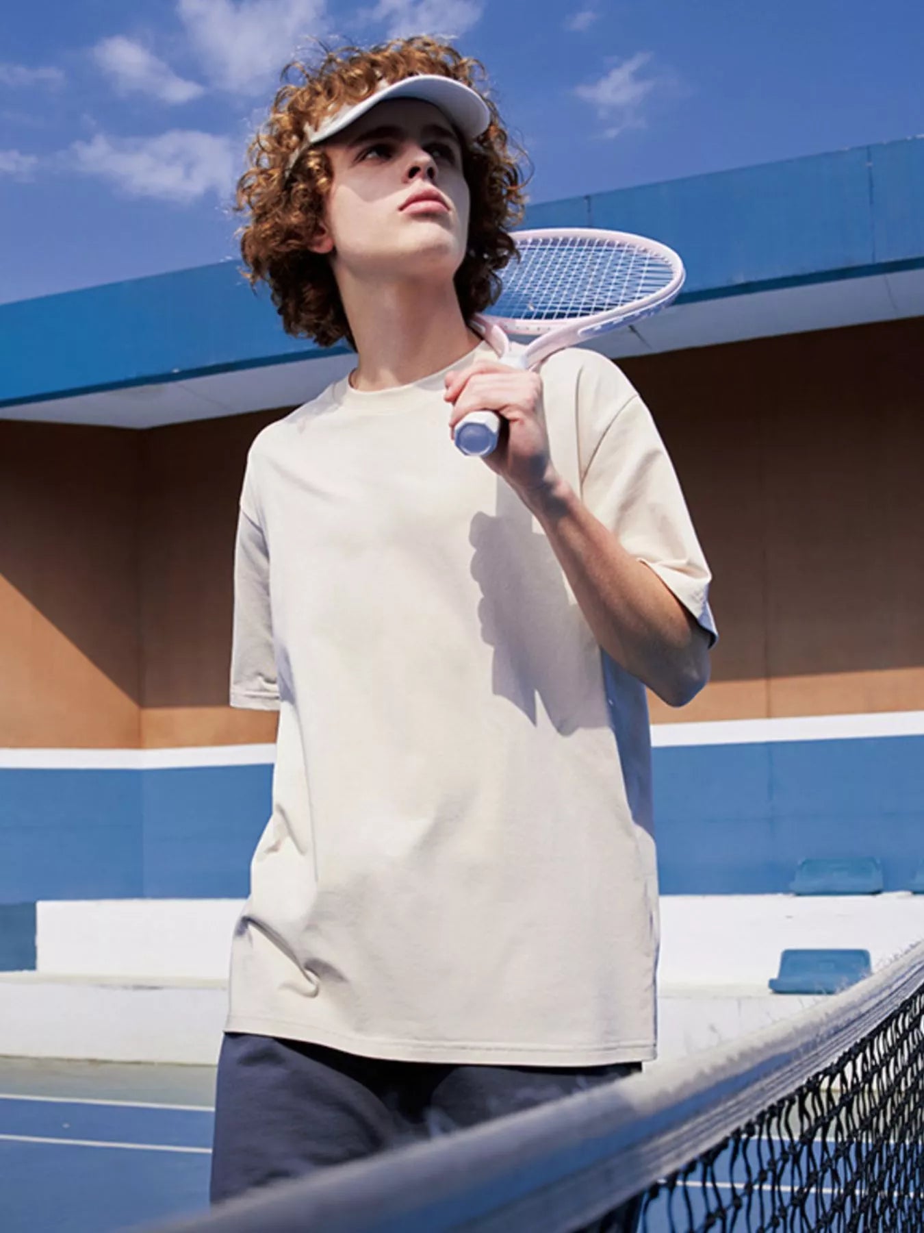 NEWYORKLISTED ATLAS MEN's COLLECTION: Person holding a tennis racket on a tennis court with a blue sky background