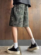 NEWYORKLISTED ATLAS MEN's COLLECTION: Person wearing camouflage shorts and black sneakers on a wooden floor.