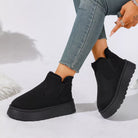 NEWYORKLISTED SHOE COLLECTION: A person wearing black platform ankle boots with a fuzzy trim, paired with light blue skinny jeans, shown against a white studio background.