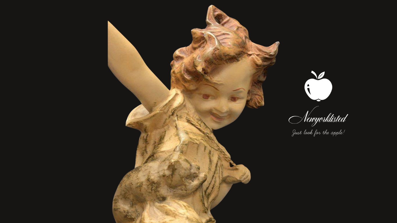 NEWYORKLISTED Unique Finds Collection: Statue of a cherub holding an apple with 'Neverfull' logo on a black background