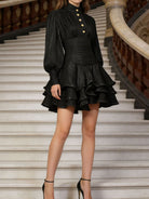 NEWYORKLISTED STYLE COLLECTION: Person wearing a black dress with gold buttons on a staircase