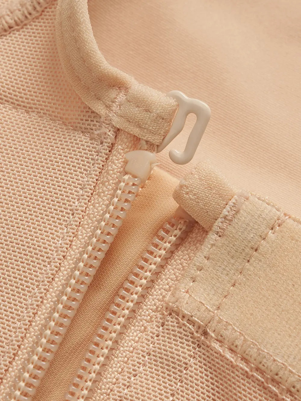 NEWYORKLISTED Intimate Apparel: Close-up of a beige fabric with a zipper and button