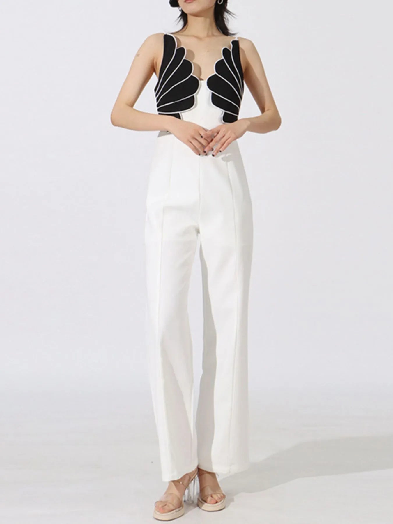 NEWYORKLISTED: Woman wearing a black and white outfit with a unique top design on a white background