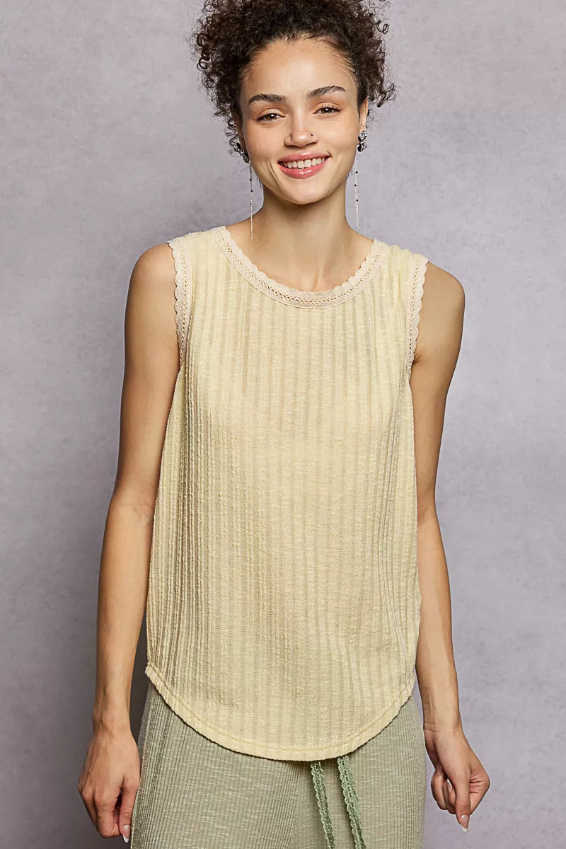 NEWYORKLISTED STYLE COLLECTION: Woman wearing a light-colored sleeveless top against a gray background