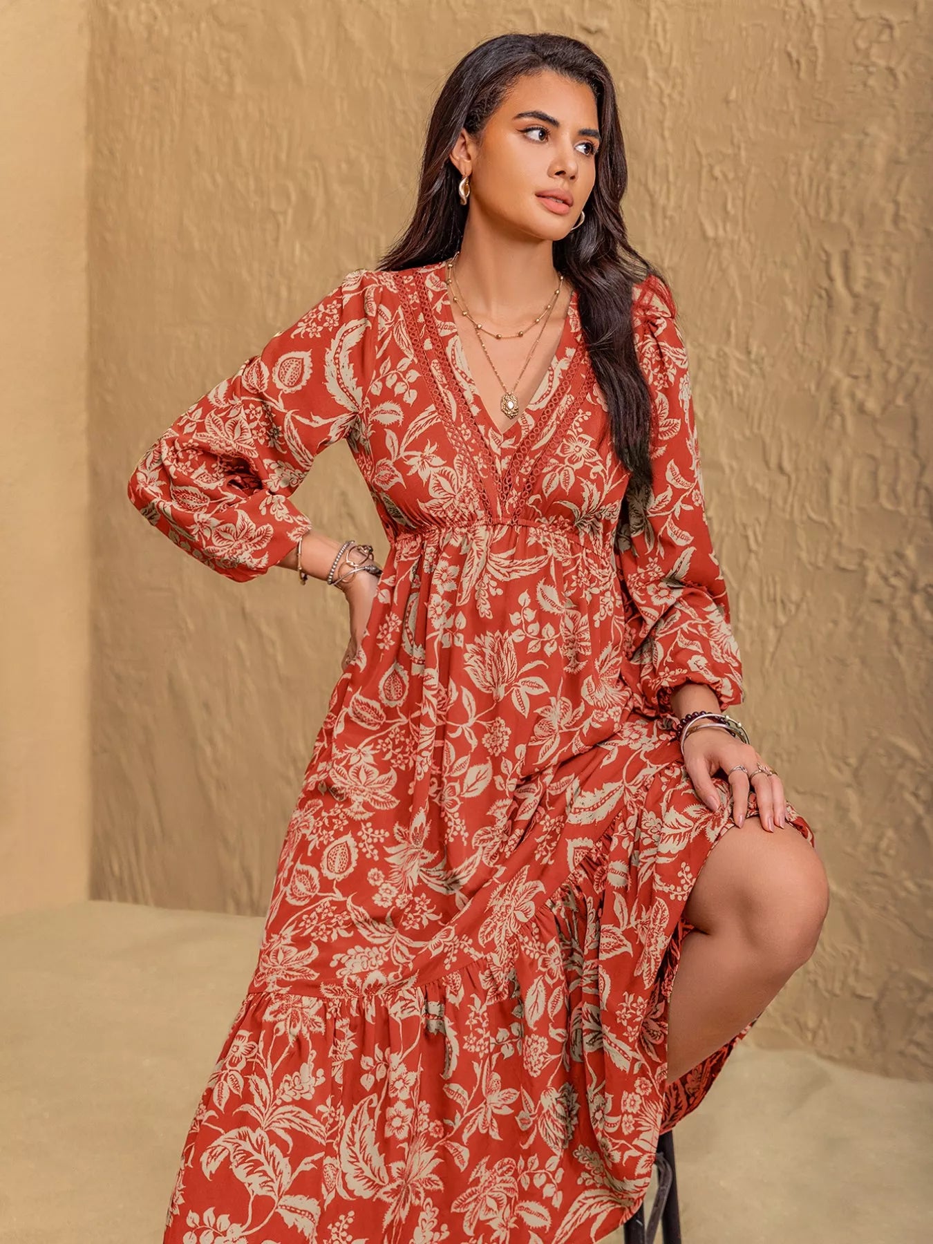 NEWYORKLISTED STYLE COLLECTION: Woman wearing a red floral dress against a beige background