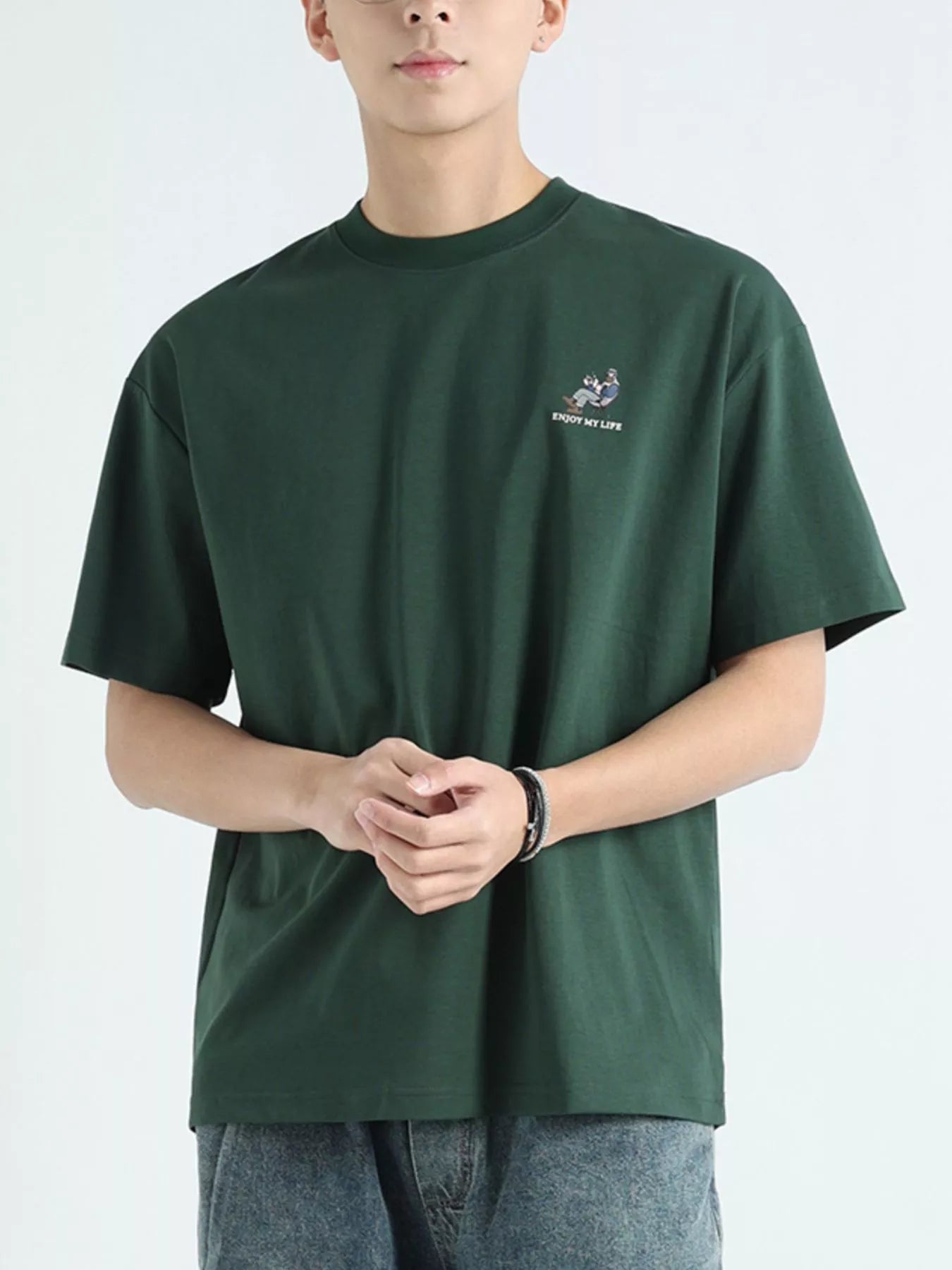 NEWYORKLISTED ATLAS MEN'S COLLECTION: Person wearing a green t-shirt with a small logo on a light gray background