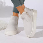 NEWYORKLISTED SHOE COLLECTION: A pair of off-white platform slip-on boots with fluffy white faux-fur trim, shown on a model wearing blue jeans against a white studio background.