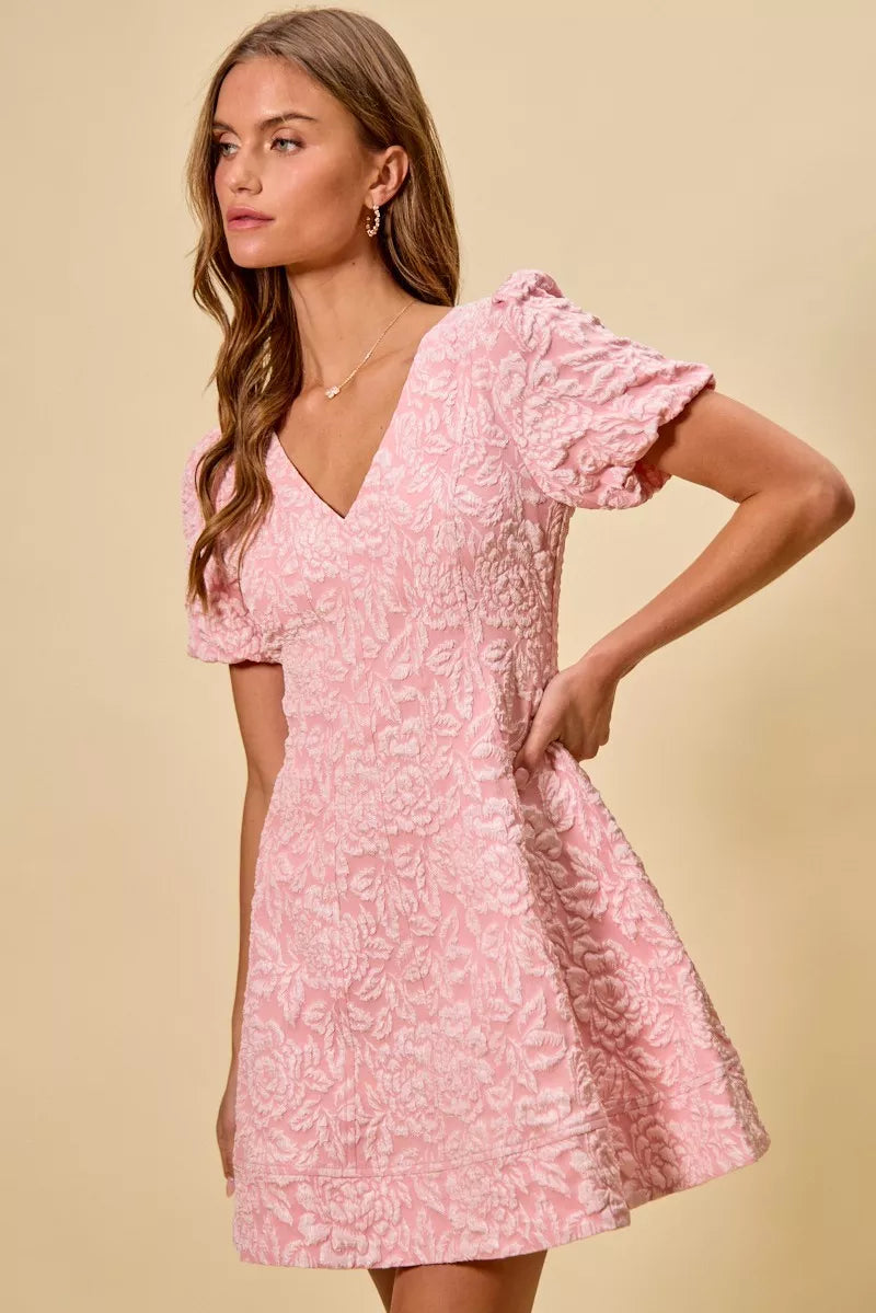 NEWYORKLISTED STYLE COLLECTION: Woman wearing a pink floral dress against a beige background