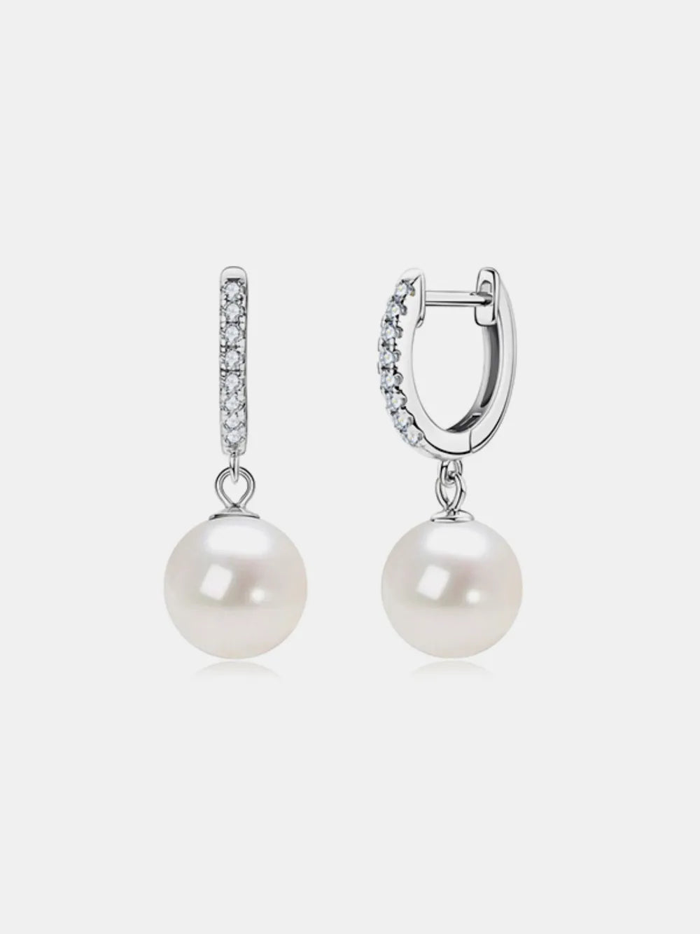 NYLD GLAMOUR COLLECTION by NEWYORKLISTED: Pair of pearl earrings with silver hooks on a light gray background