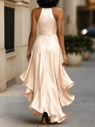NEWYORKLISTED STYLE COLLECTION: Woman wearing a long, elegant beige dress walking outdoors.