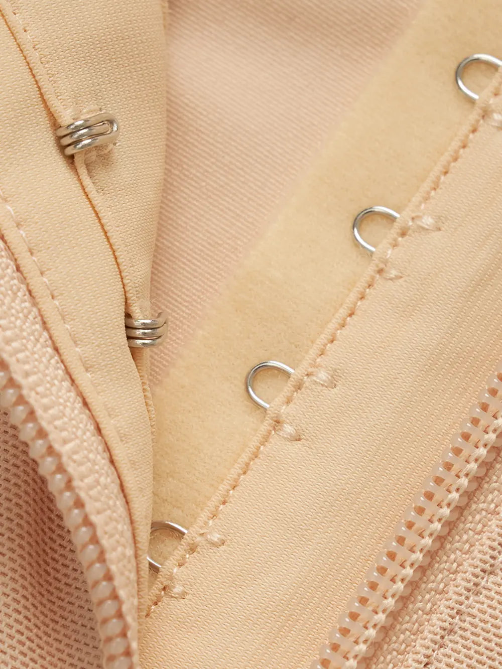 NEWYORKLISTED Intimate Apparel: Close-up of beige fabric with metal grommets and stitching details