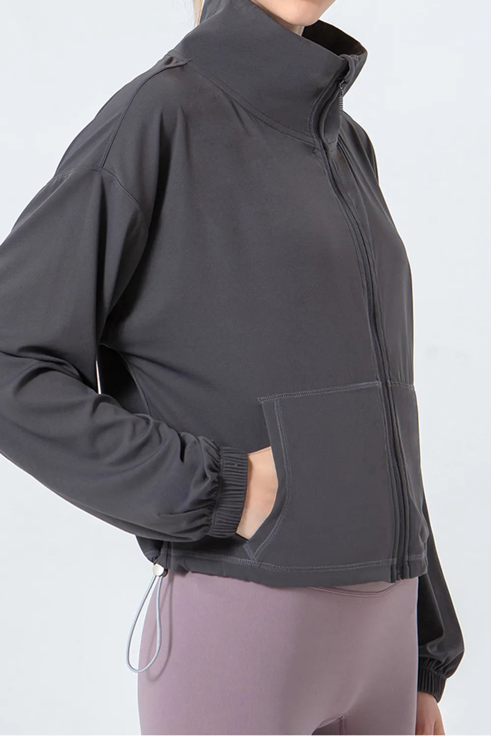 NEWYORKLISTED ACTIVEWEAR COLLECTION: Person wearing a dark gray jacket with a white background