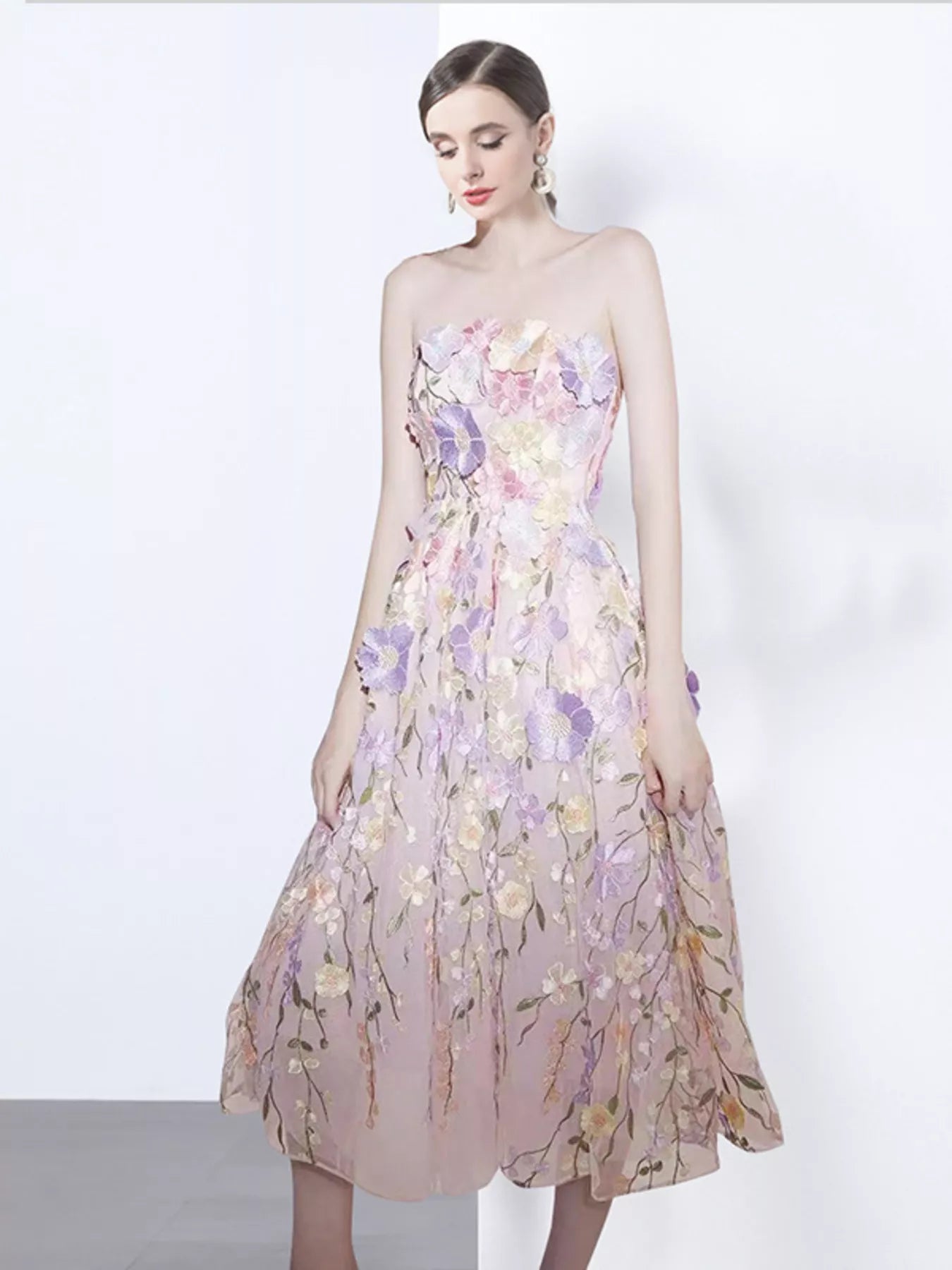 NEWYORKLISTED STYLE COLLECTION: Woman wearing a strapless floral dress on a white background