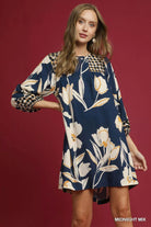 NEWYORKLISTED STYLE COLLECTION: Woman wearing a floral dress with long sleeves on a red background