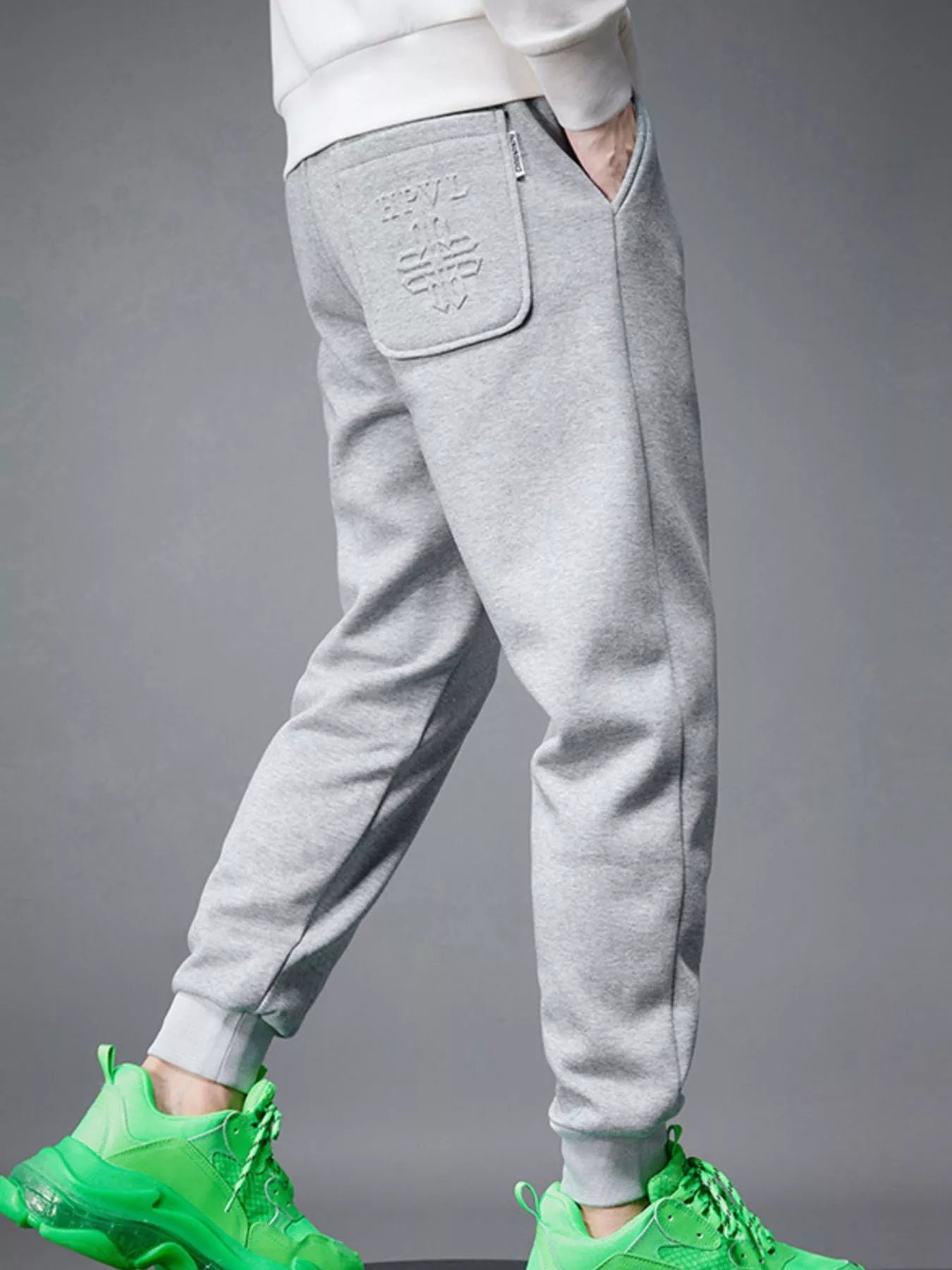 NEWYORKLISTED ATLAS MEN's COLLECTION: Gray sweatpants worn by a person with green sneakers on a gray background