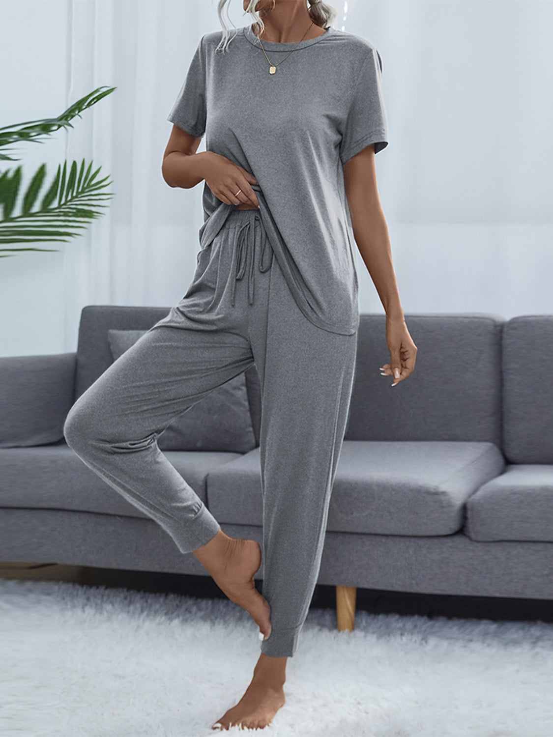 NEWYORKLISTED Intimate Apparel: Person wearing a gray lounge set in a living room setting.