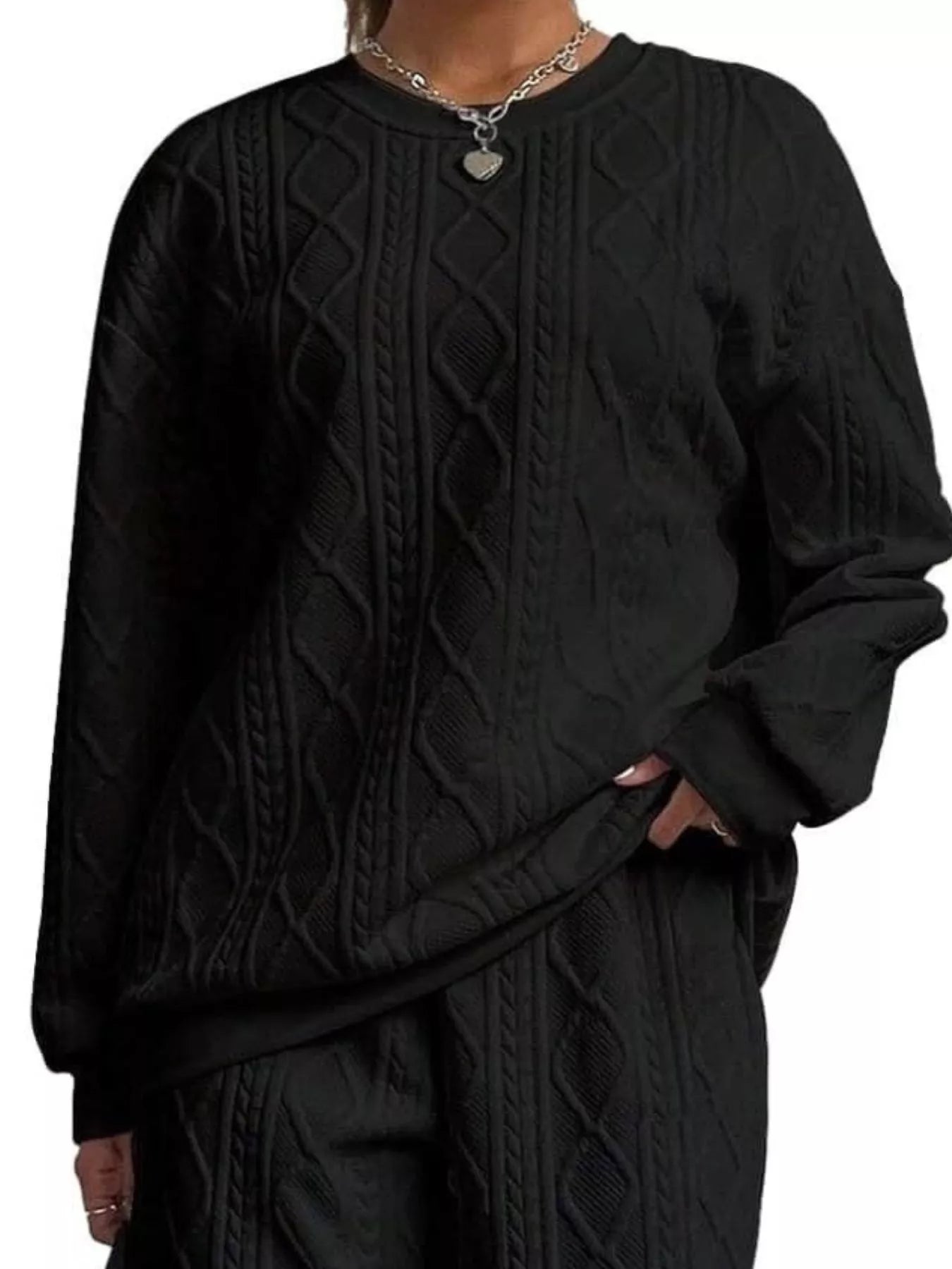 NEWYORKLISTED COMFORT COLLECTION: Black cable knit sweater worn by a person on a white background