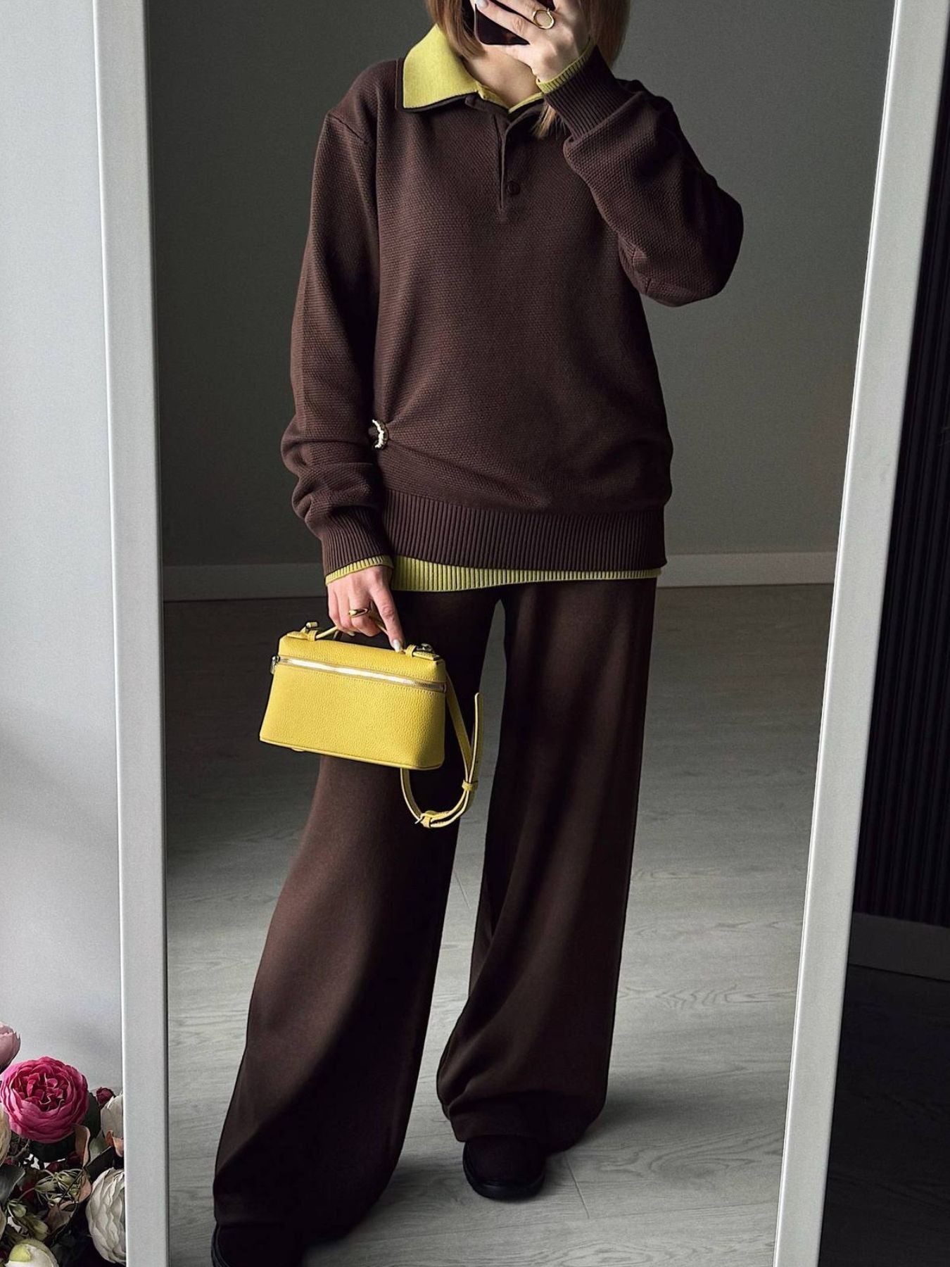 NEWYORKLISTED Comfort Collection: Person wearing a brown outfit with a yellow handbag in front of a mirror.