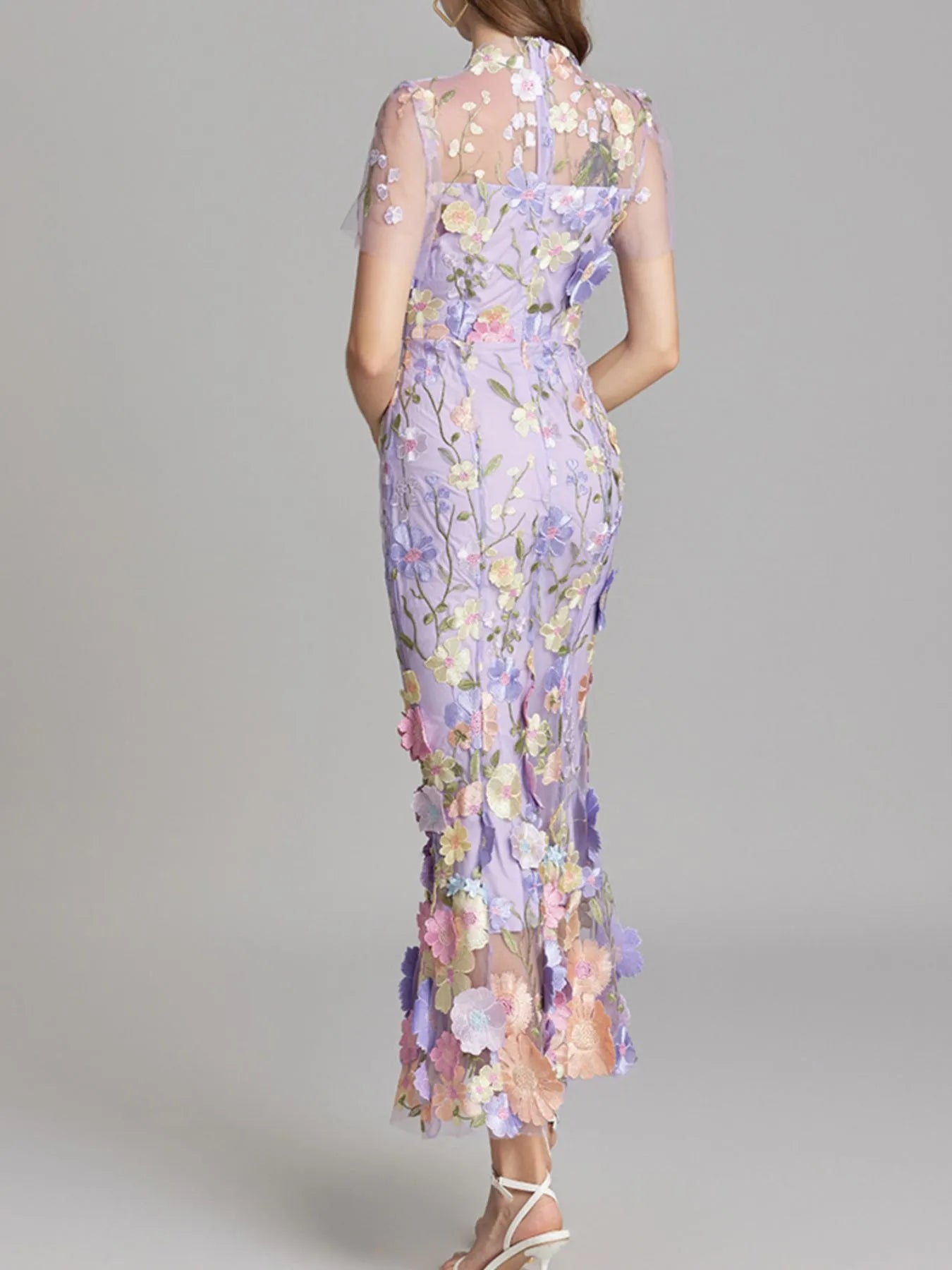 NEWYORKLISTED STYLE COLLECTION: Woman wearing a floral dress with a gray background
