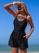 NEWYORKLISTED EDEN COLLECTION: Woman in a black romper with leopard print accents taking a selfie on a beach.
