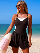 NEWYORKLISTED EDEN COLLECTION: Woman in a black and white romper on a beach with blue sky and ocean.