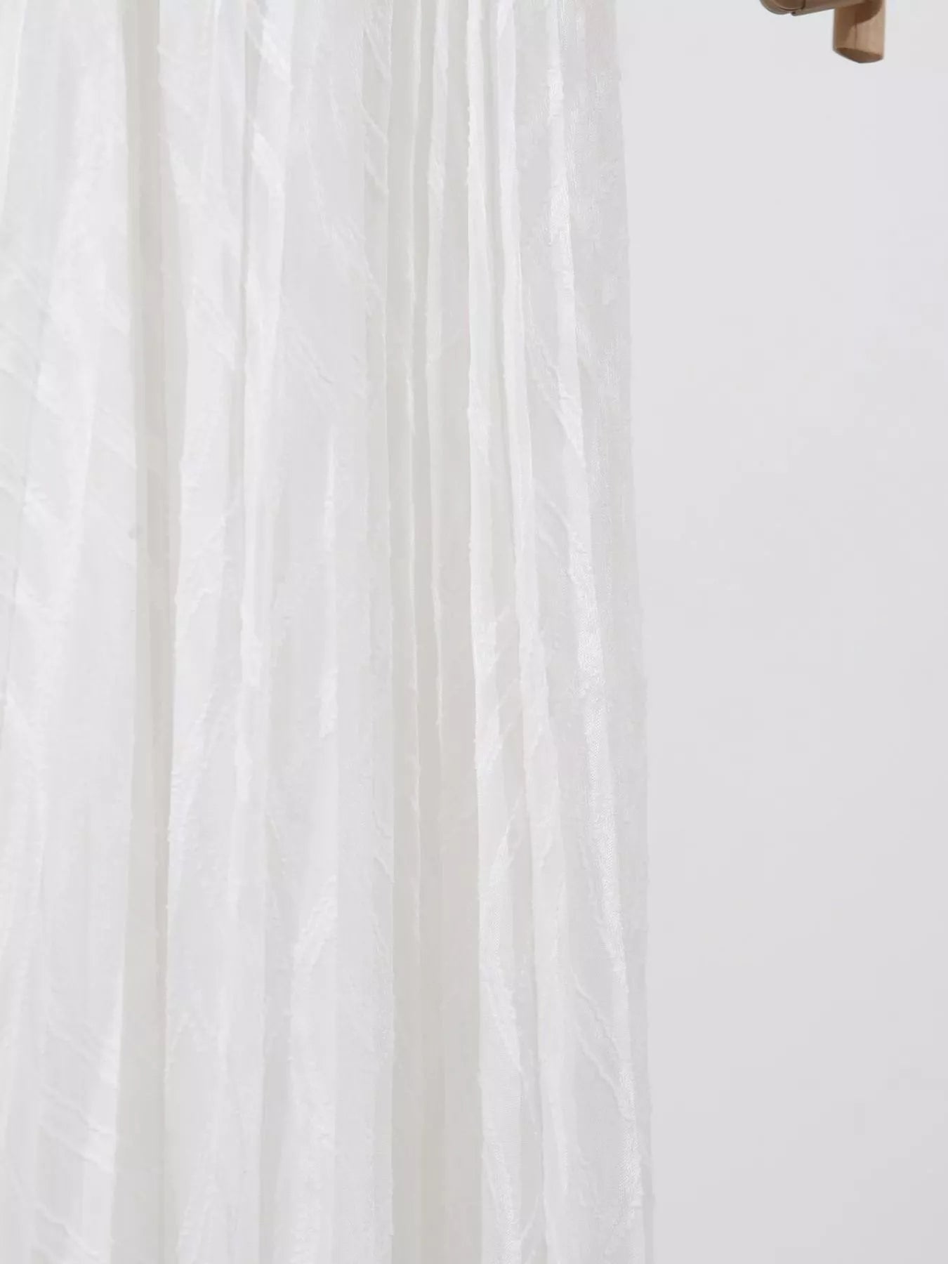 NEWYORKLISTED STYLE COLLECTION: Close-up of white fabric with a subtle pattern on a light background