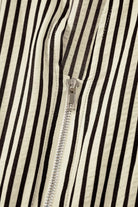 NEWYORKLISTED STYLE COLLECTION: Close-up of a black and white striped fabric with a zipper running vertically.