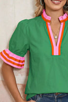 NEWYORKLISTED STYLE COLLECTION: Green blouse with colorful trim worn by a person, against a neutral background