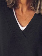 NEWYORKLISTED STYLE COLLECTION: Close-up of a person wearing a dark sweater with a white collar.