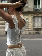 NEWYORKLISTED STYLE COLLECTION: Woman wearing a white lace top and skirt on a street.