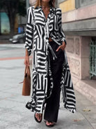 NEWYORKLISTED STYLE COLLECTION: Person wearing a long black and white patterned shirt with black pants on a city street.