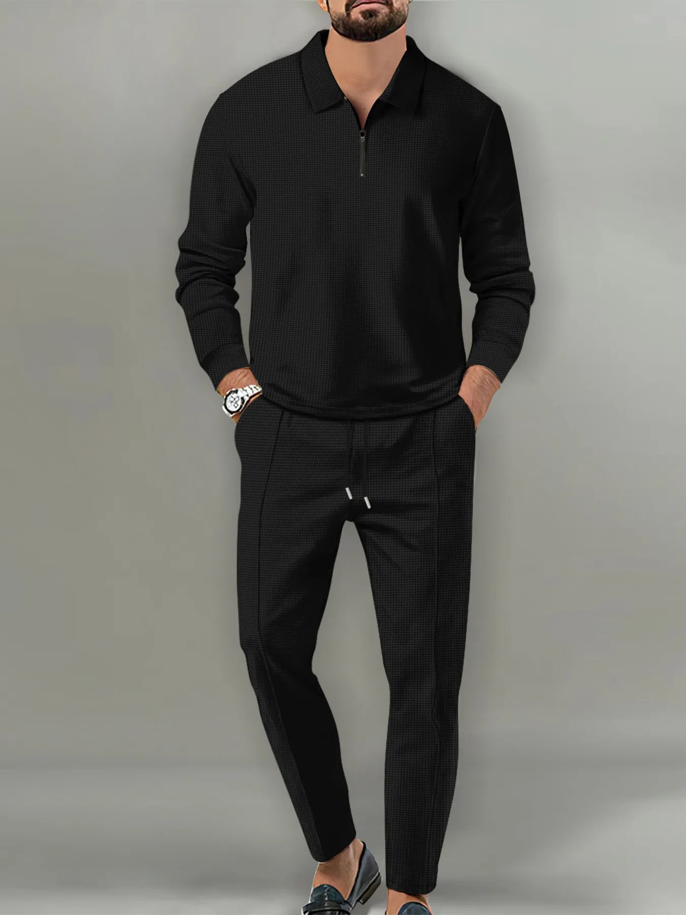 NEWYORKLISTED ATLAS MEN'S COLLECTION: Man wearing a black long-sleeve shirt and black pants against a gray background