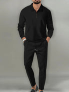 NEWYORKLISTED ATLAS MEN'S COLLECTION: Man wearing a black long-sleeve shirt and black pants against a gray background